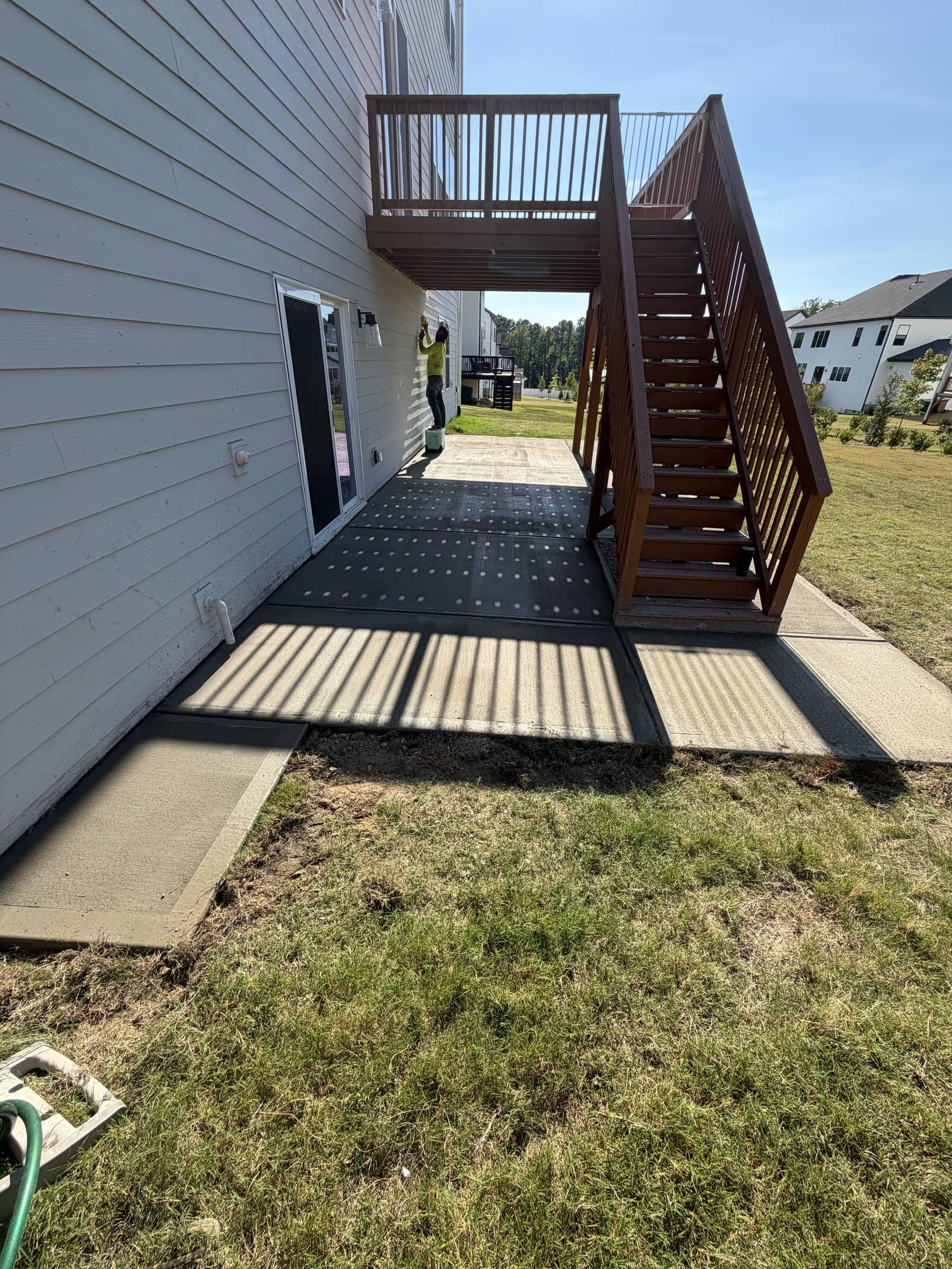 Finished concrete patio under a backyard deck in the Cary–Apex area