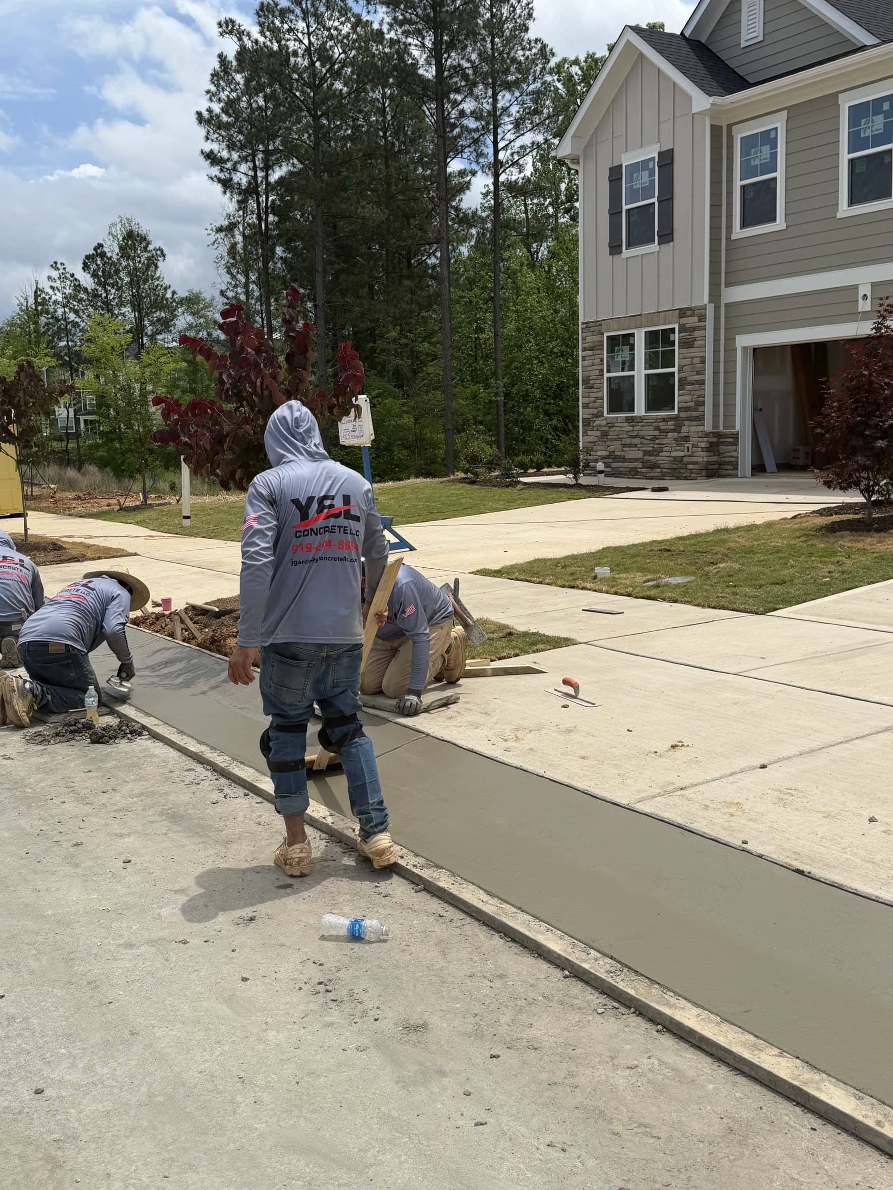Y&L Concrete crew finishing a curb and sidewalk at a townhome community near Holly Springs, NC